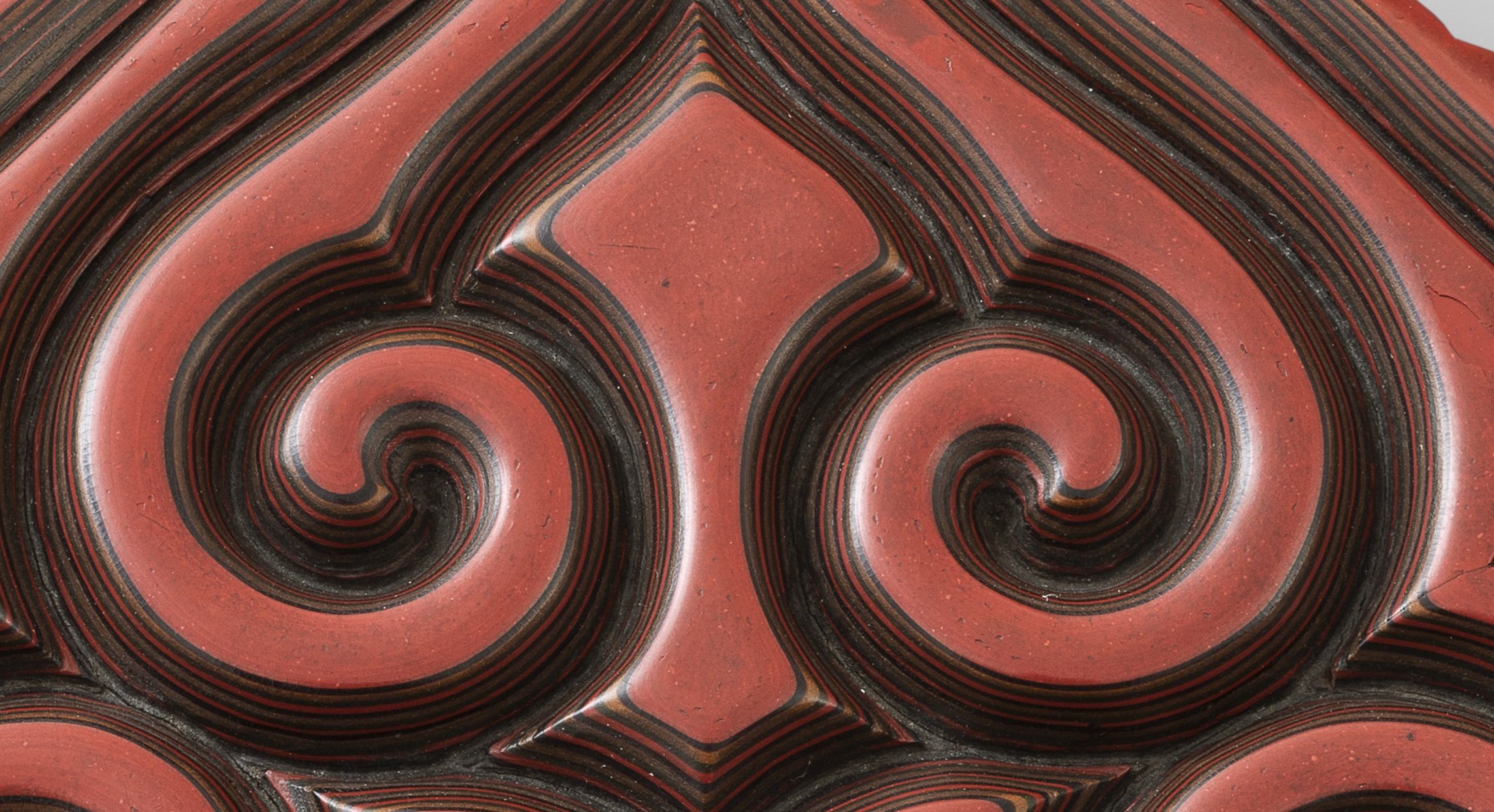 Detailaufnahme einer roten Schnitzlackdose.