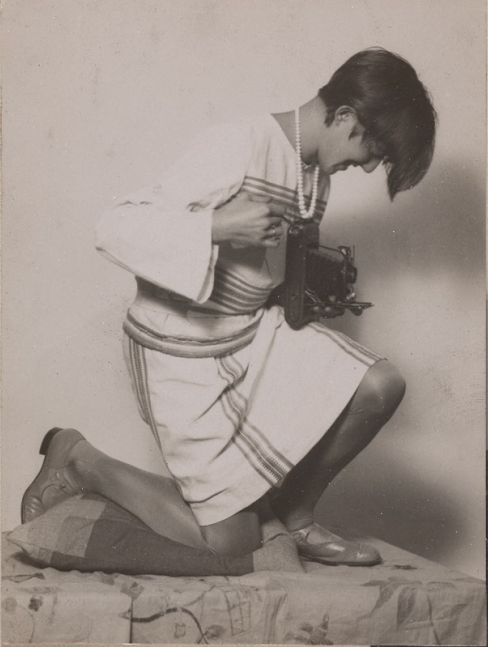 Annelise knieend mit Kamera in ihren Händen. (Repro: LWL-MKuK/Hanna Neander ©Nachlass Annelise Kretschmer, LWL-Museum für Kunst und Kultur, Münster)