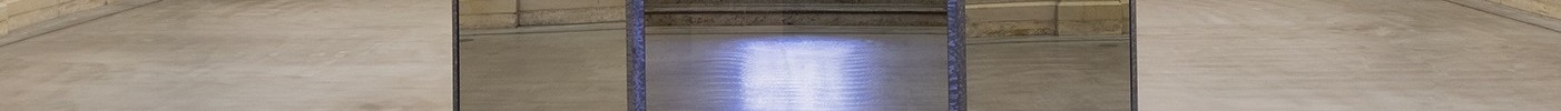 Das Bild zeigt einen historischen Raum mit vielen Säulen und mehreren Etagen. In der Mitte steht ein Spiegelpavillon.