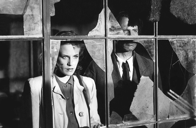 Eine Frau und ein Mann stehen an einem Fenster und schauen hinaus.