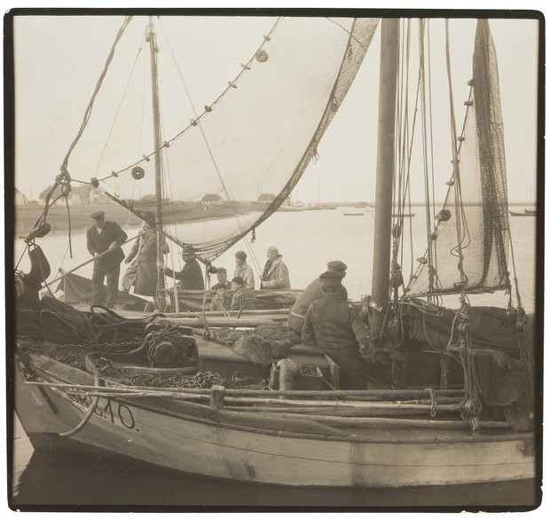 Fischerboot mit mehreren Fischern und ausgebreiteten Netzen.