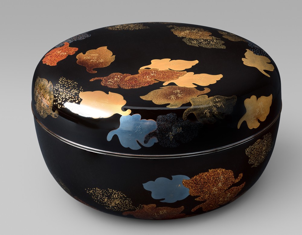 Japanische Süßigkeiten-Dose mit Herbstblättern aus Goldstreulack auf schwarzem Grund.