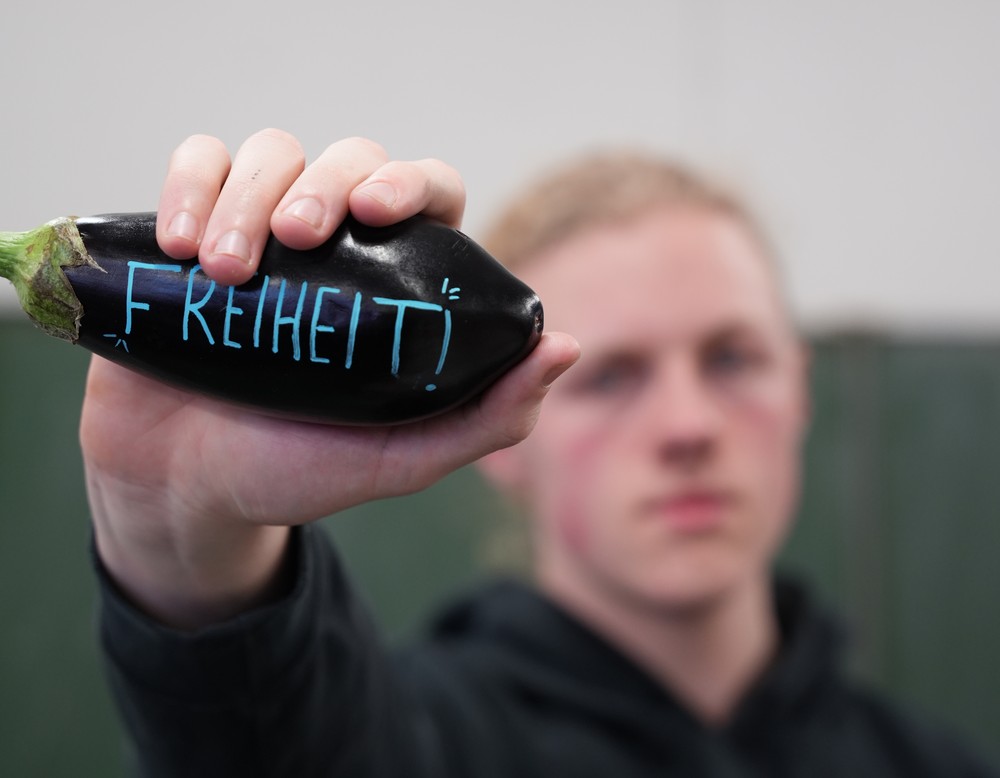 Schüler zeigt beschriftete Aubergine