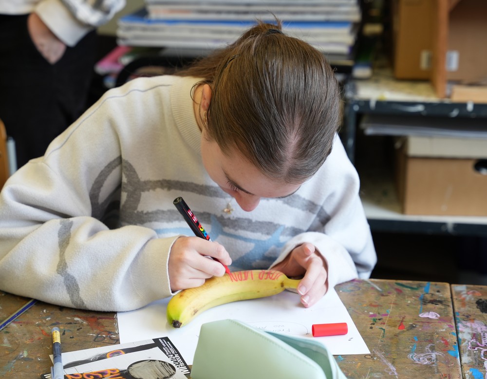 Schülerin beschriftet eine Banane