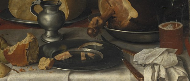 Detail des Tisches mit Teller, Krügen und Speisen, wie Brot und Obst.