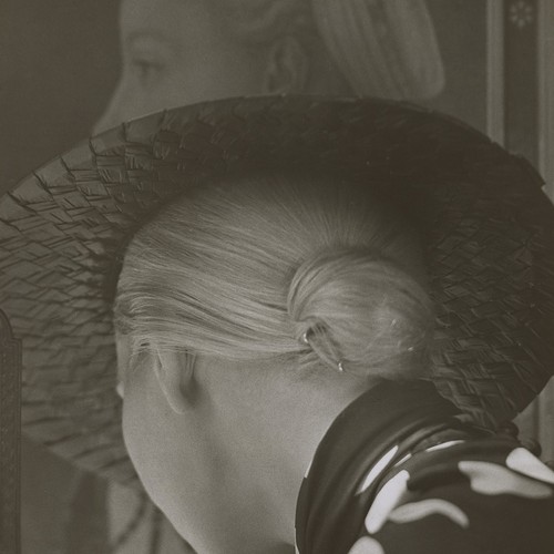 Hinterkopf einer Frau mit gebundenem Haarknoten und Hut