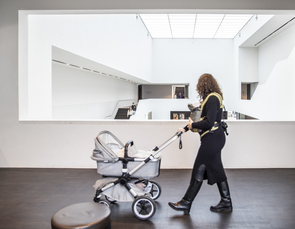 Frau mit Kinderwagen im Museum