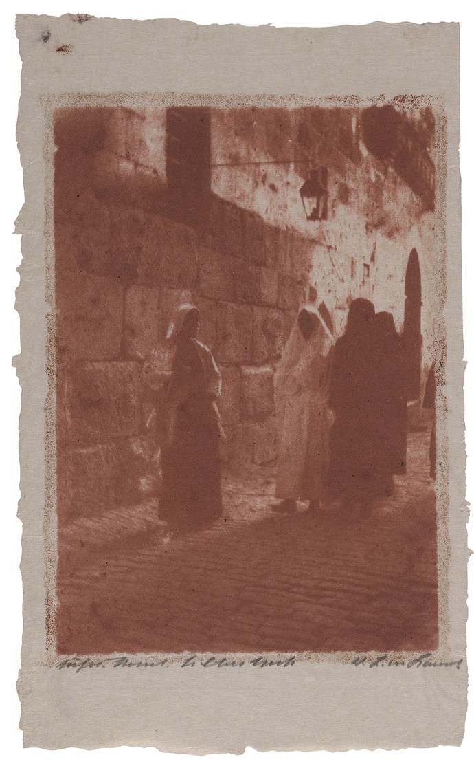 Drei Personen in weiten Gewändern vor einer Mauer in Jerusalem.