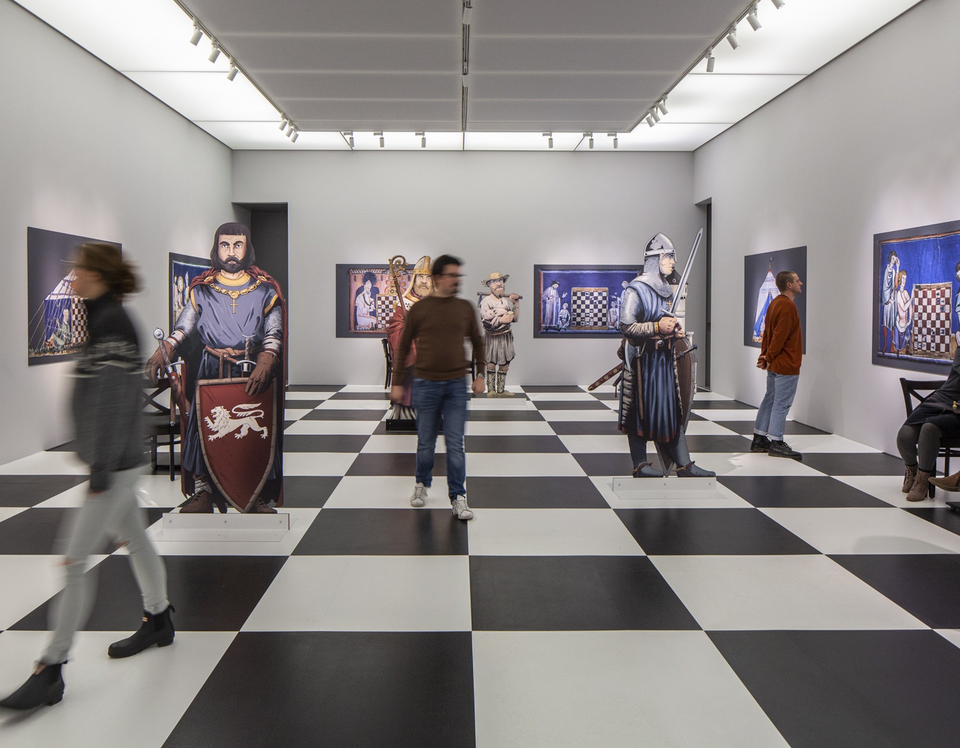 Ein Raum in der Ausstellung mit Schachfiguren und dem Schachmuster auf dem Boden.