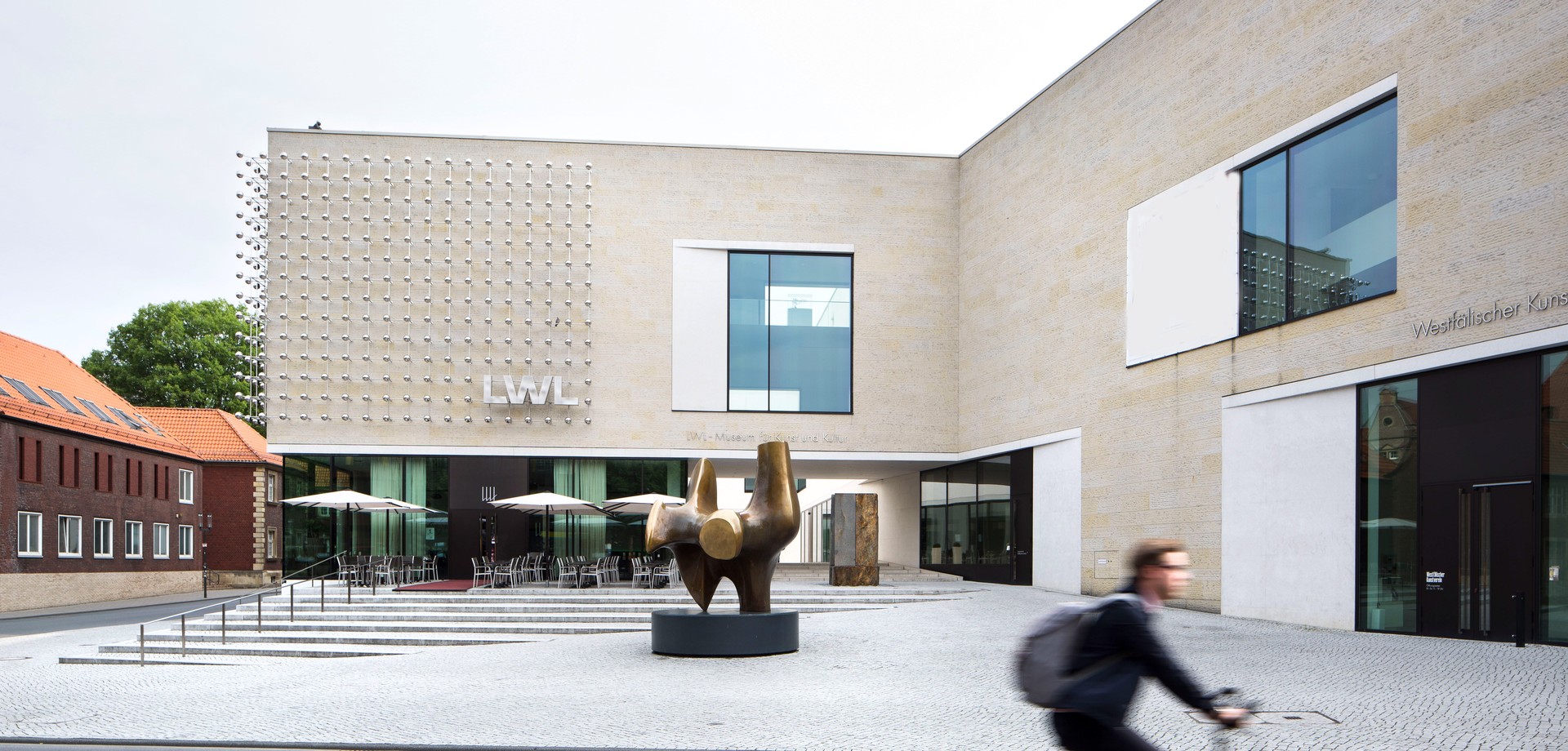 Cyclist passes in front of the LWL-Museum für Kunst und Kultur.