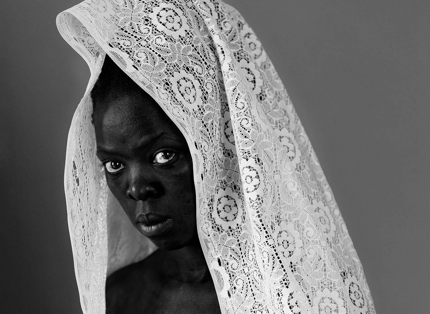 person of colour with white lace veil
