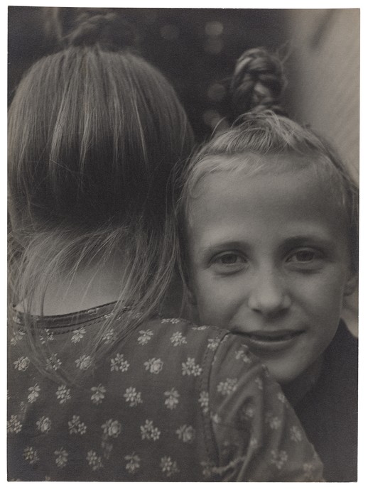 Zwei Kinder umarmen sich, ein Mädchen schaut in die Kamera. (vergrößerte Bildansicht wird geöffnet)