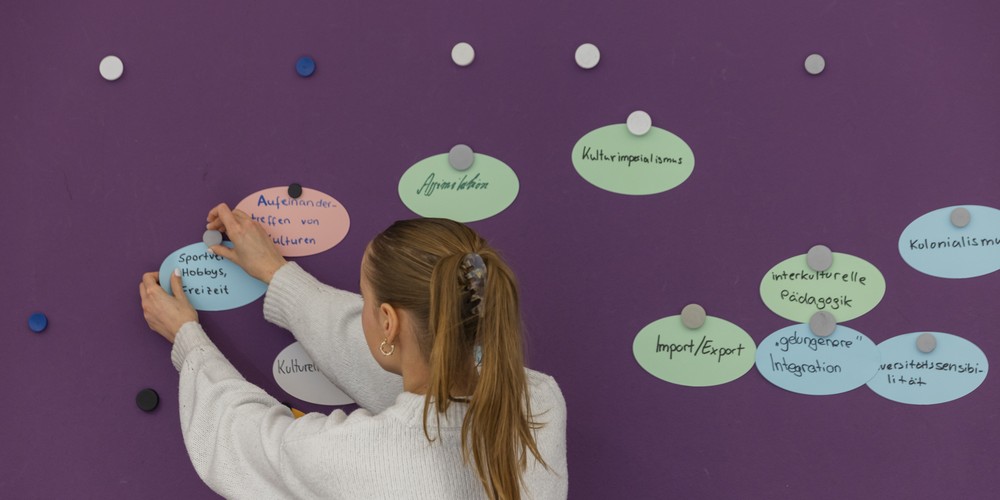 Child organises Notes infront of a wall
