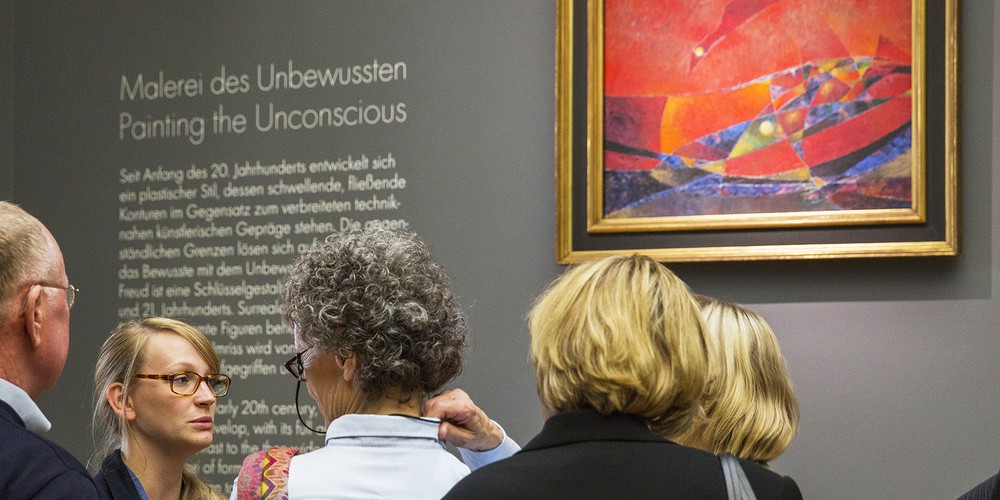 Frau spricht über ein Kunstwerk.