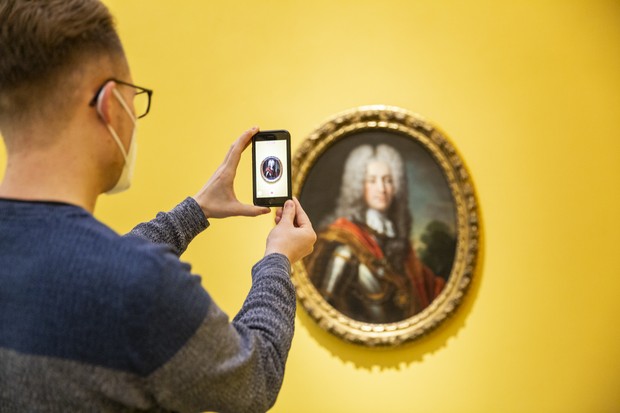 Kunstvermittler filmt mit dem Smartphone Gemälde Kunstvermittler filmt mit dem Smartphone Gemälde