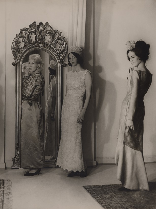 Modefotografie mit drei Frauen in Abendkleidern, im Hintergrund ein Spiegel.