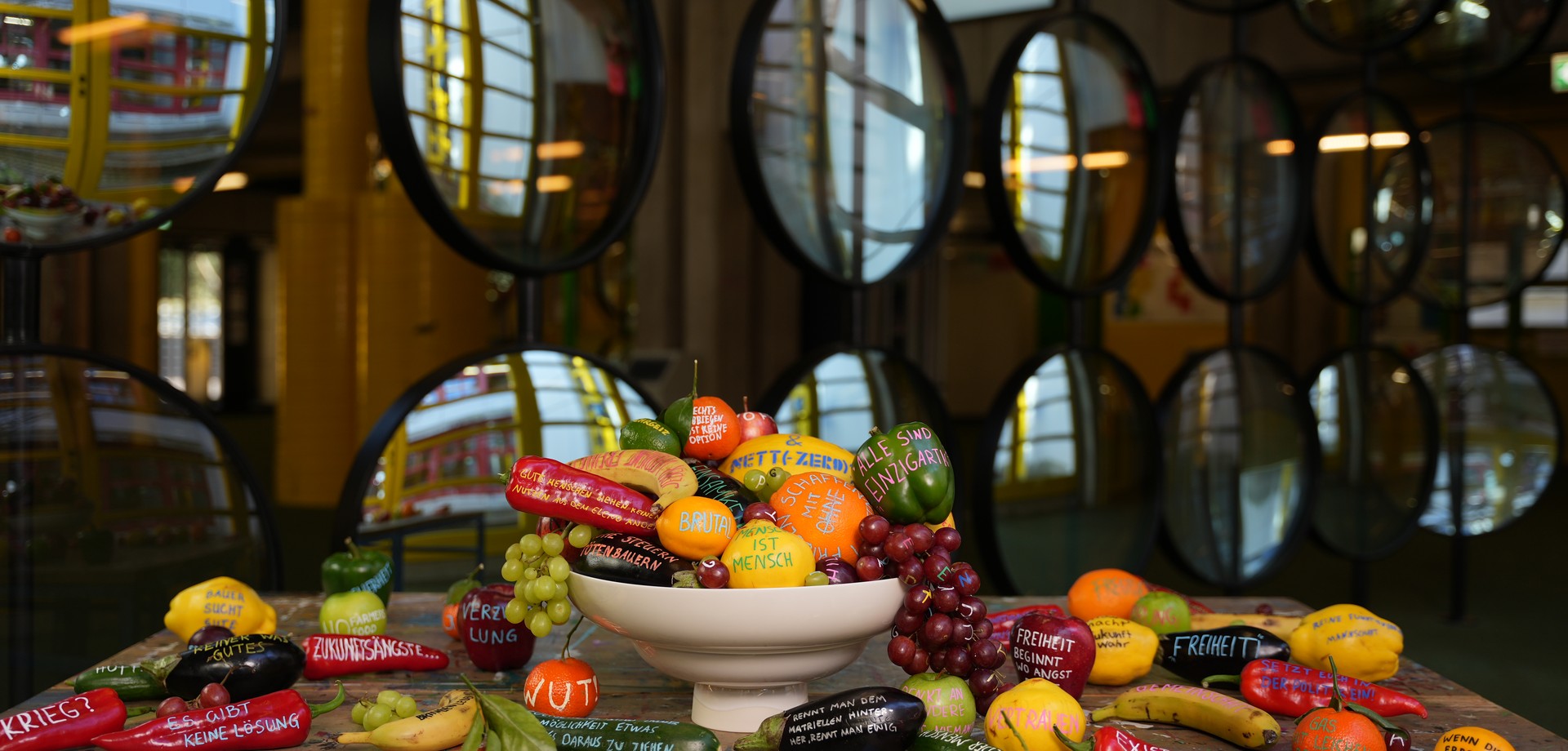 Das Foto zeigt Hafiza Qasimi beim Malen des Wandbildes.