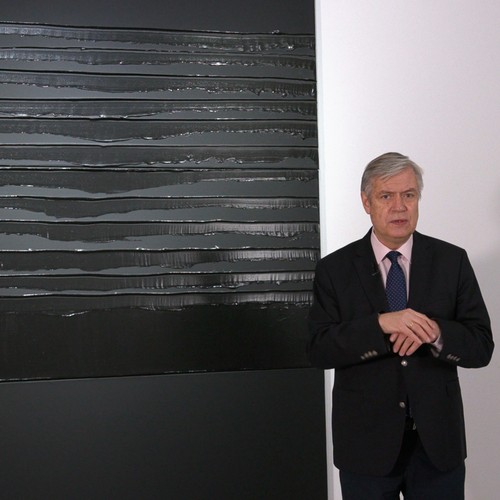 Direktor Dr. Hermann Arnhold steht vor einem Gemälde von Pierre Soulages