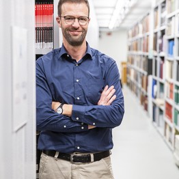 Portrait von Herrn Zangel vor einem Bücherregal