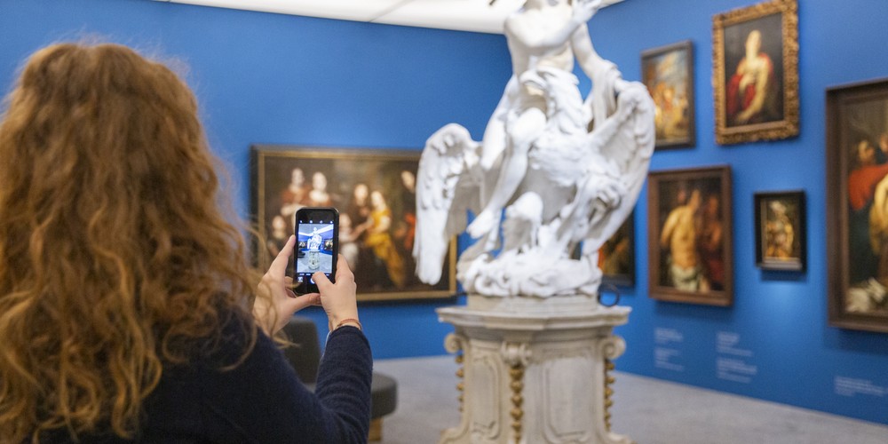 Woman with a phone infront of a statue