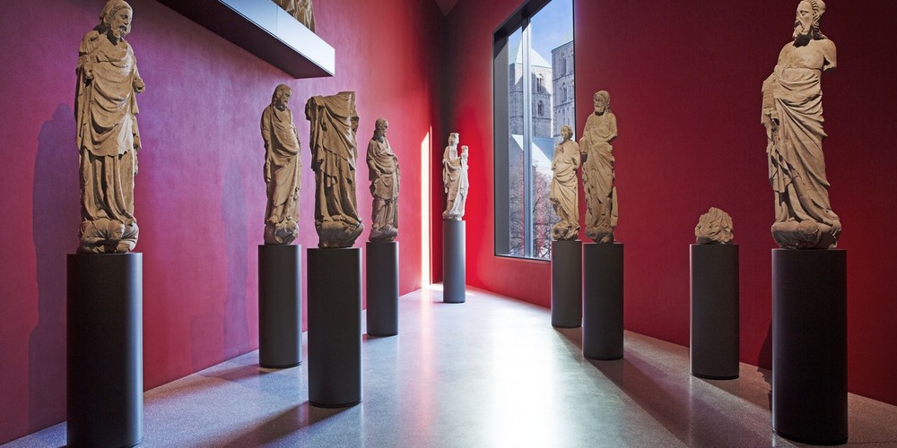 Ein Spitz zulaufender Raum im Museum. In dem Raum stehen Skulpturen
